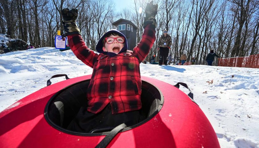 Child on inner tube at tubing hill at Powers Bluff County Park in Wood County Marshfield Wisconsin